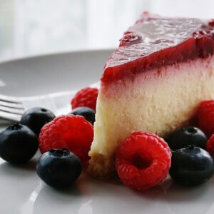 A tempting slice of cheesecake topped with berries, perfect for dessert lovers.