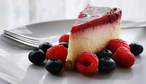 A tempting slice of cheesecake topped with berries, perfect for dessert lovers.