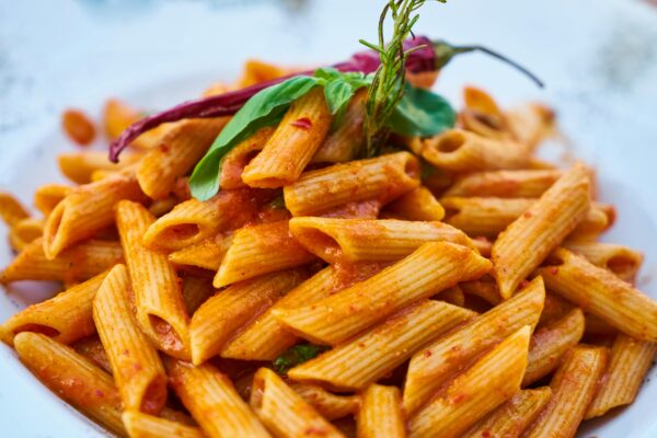 Savor the flavors of Italian cuisine with this close-up photo of tasty penne pasta in tomato sauce.