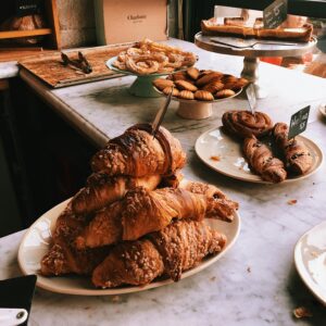 A tempting assortment of croissants and pastries on a marble countertop, perfect for a bakery theme.