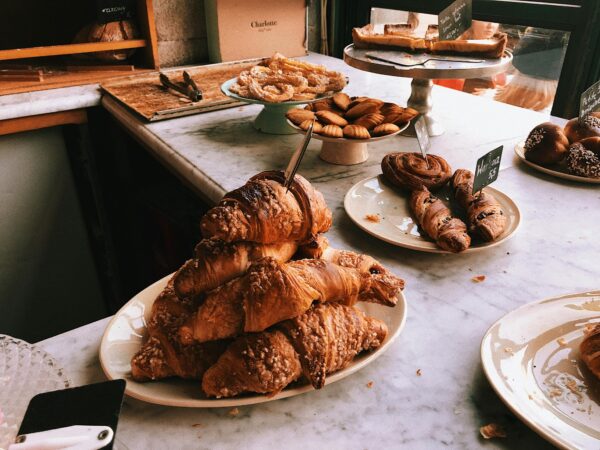 A tempting assortment of croissants and pastries on a marble countertop, perfect for a bakery theme.