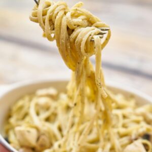 A close-up of creamy Italian pasta with basil and cheese, perfect for a delicious meal.