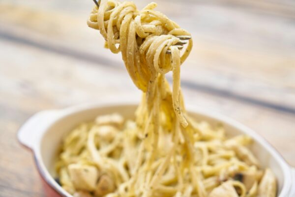 A close-up of creamy Italian pasta with basil and cheese, perfect for a delicious meal.