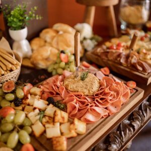 Delightful charcuterie board with meats, cheeses, and fresh fruits at an event setup.