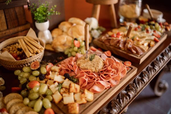 Delightful charcuterie board with meats, cheeses, and fresh fruits at an event setup.