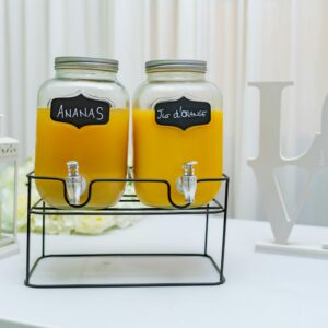 Elegant setup of pineapple and orange juice dispensers in glass jars, perfect for events.