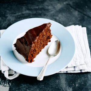 Slice of frosted chocolate cake on a plate