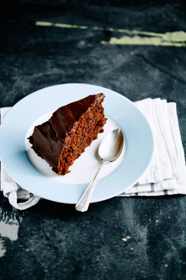 Slice of frosted chocolate cake on a plate