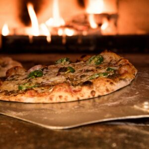 Appetizing gourmet pizza cooked in a wood-fired oven, showcasing artisanal toppings.