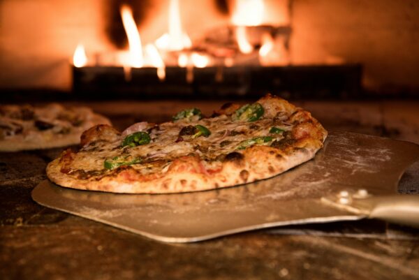 Appetizing gourmet pizza cooked in a wood-fired oven, showcasing artisanal toppings.